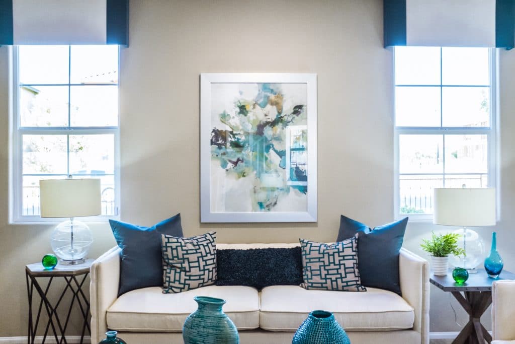 Sitting room showcasing a couch in the center with blue decorative accents around the room.