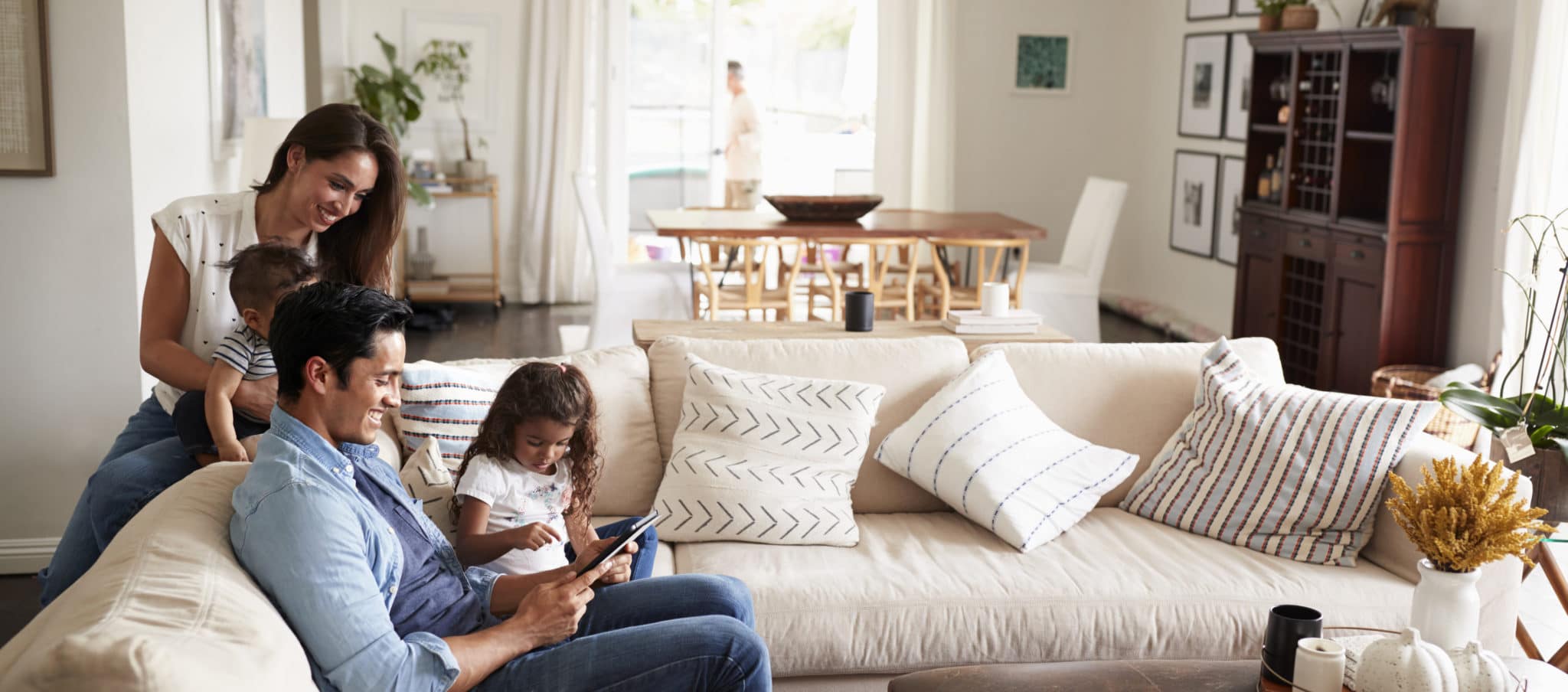 Young family sitting on a sofa together in a living room.